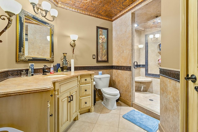 bathroom with an ornate ceiling, a wainscoted wall, tile walls, a shower stall, and vanity