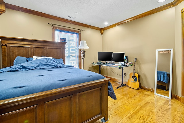 bedroom with baseboards, visible vents, a textured ceiling, crown molding, and light wood-style floors