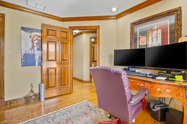 office with a textured ceiling, visible vents, baseboards, light wood-style floors, and crown molding