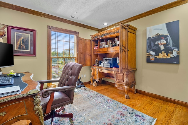 office space featuring a textured ceiling, visible vents, baseboards, light wood-style floors, and crown molding