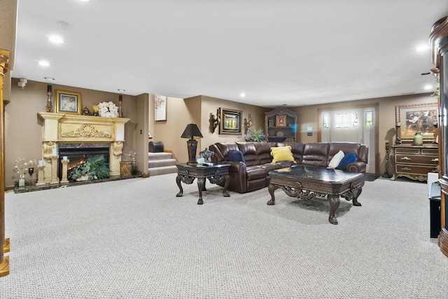 living room with stairs, carpet, a warm lit fireplace, and recessed lighting