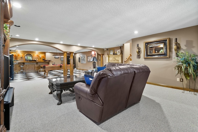 living room featuring recessed lighting, decorative columns, arched walkways, and light colored carpet