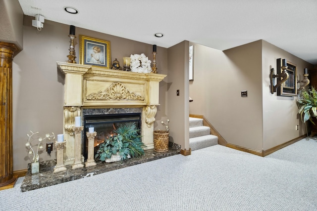 living area with recessed lighting, stairway, a high end fireplace, carpet flooring, and baseboards