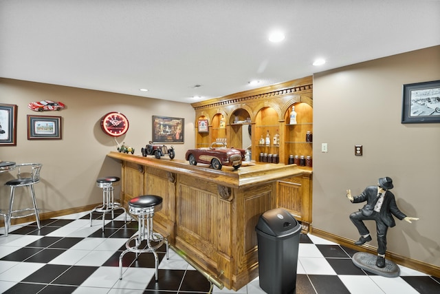 bar featuring baseboards, indoor wet bar, and recessed lighting