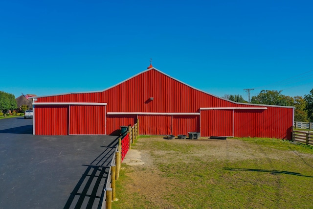 view of pole building featuring fence and a yard