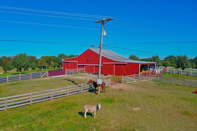 view of yard with an outbuilding, an exterior structure, and a rural view