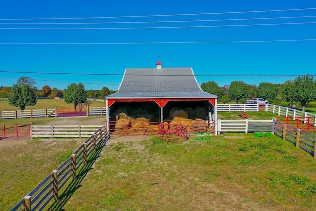 exterior space featuring an outbuilding, a rural view, and an exterior structure