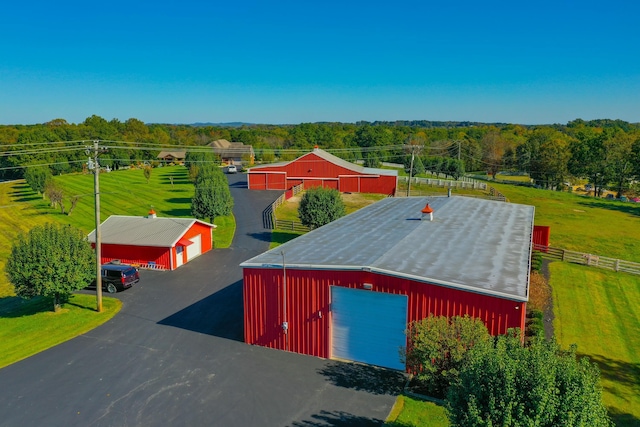 view of pole building featuring aphalt driveway and a yard