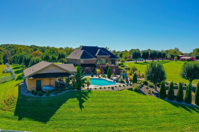 back of house featuring a patio, a lawn, and an outdoor pool