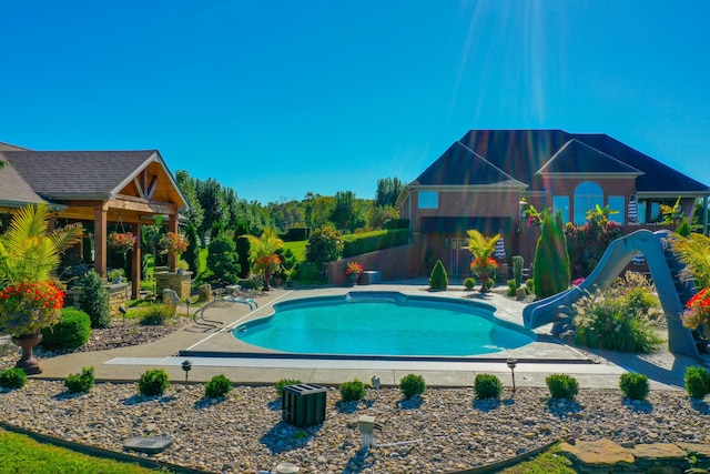 view of swimming pool featuring a fenced in pool, a water slide, and a patio