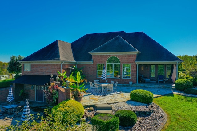 rear view of property with a patio area and brick siding