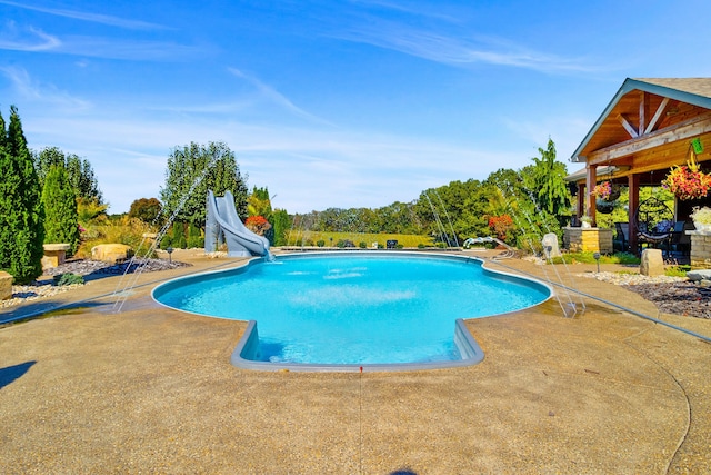 outdoor pool with a patio and a water slide