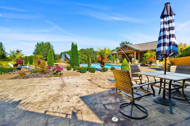 surrounding community featuring outdoor dining space, a swimming pool, and a patio area