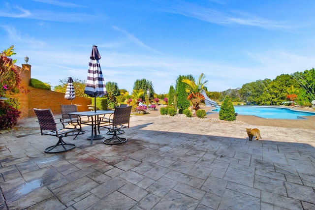 view of patio featuring outdoor dining area and an outdoor pool