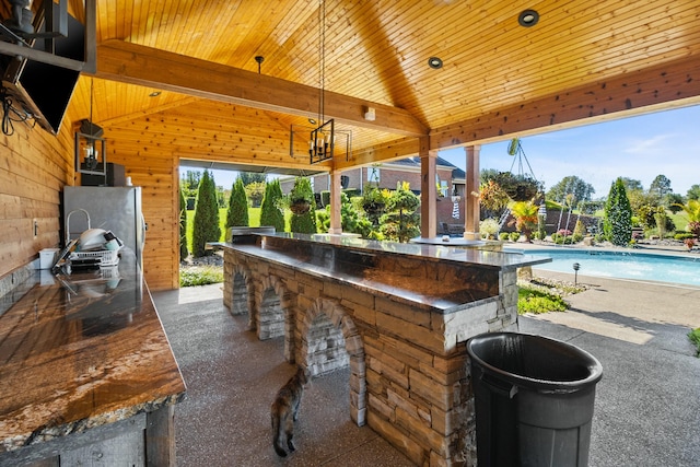 view of patio / terrace featuring a fenced in pool and an outdoor bar