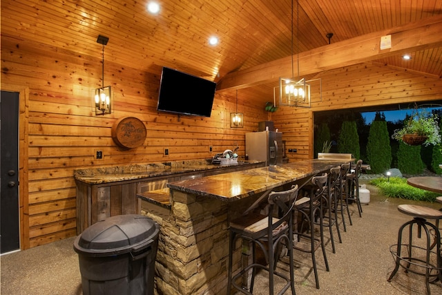 bar featuring hanging light fixtures, stainless steel fridge, light carpet, and lofted ceiling with beams