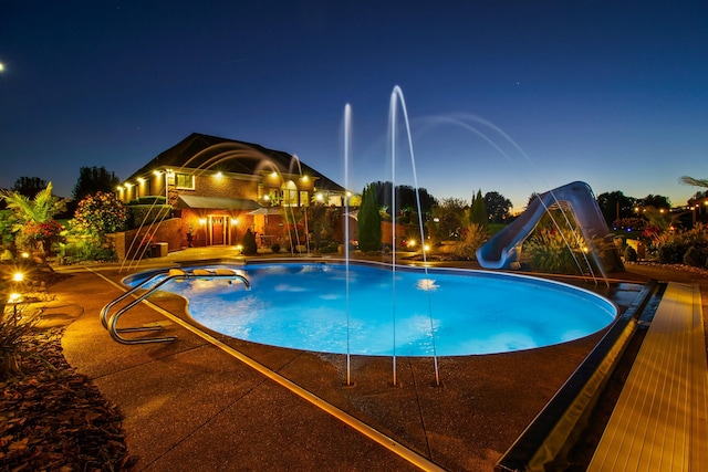 outdoor pool featuring a water slide and a patio area