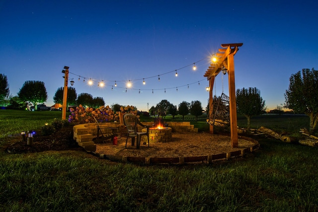 view of playground featuring a fire pit and a lawn