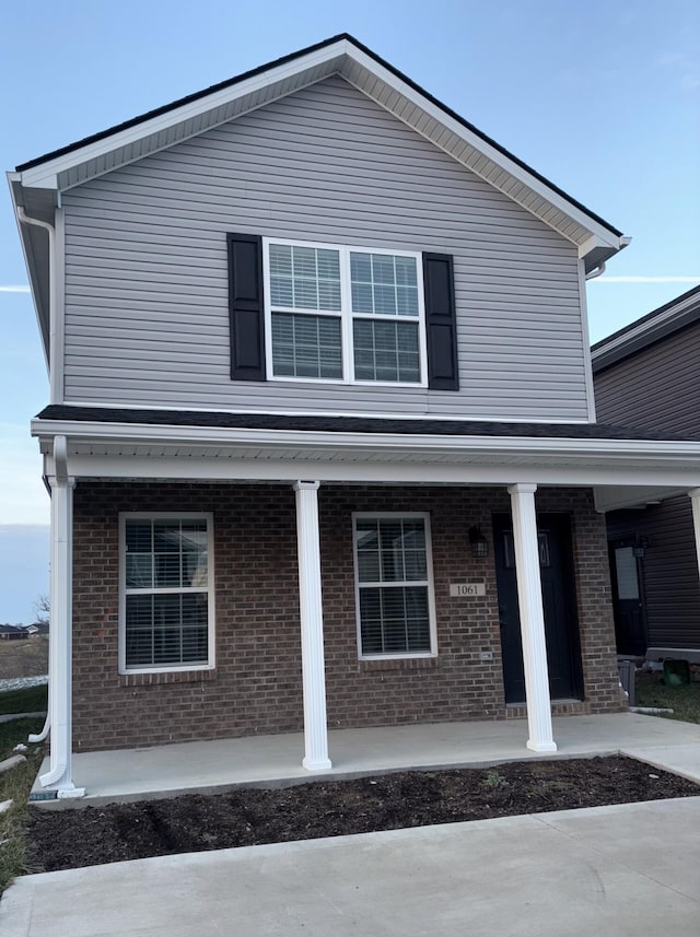 view of home's exterior with a porch and brick siding