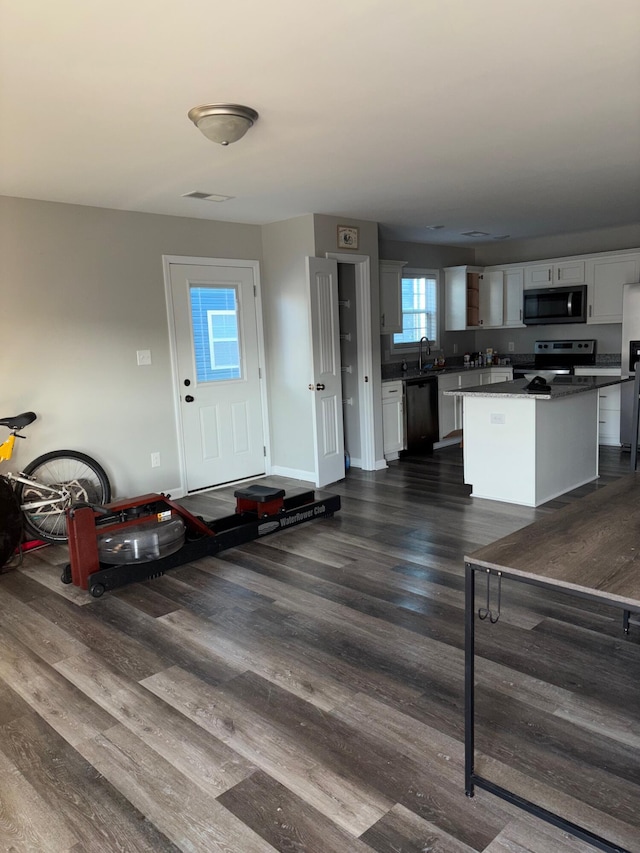 interior space with dark wood-style floors, visible vents, and baseboards