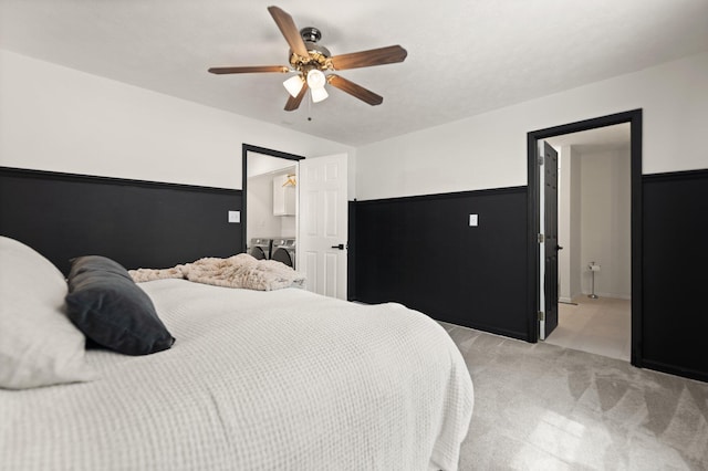 bedroom featuring light carpet, ceiling fan, and washer and dryer