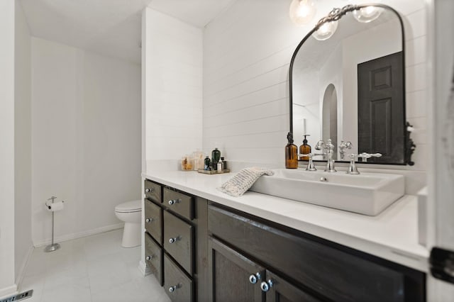 bathroom featuring toilet, visible vents, vanity, baseboards, and tile patterned floors