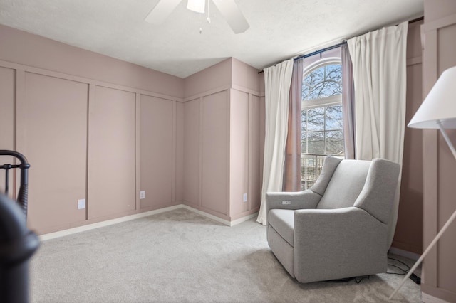 sitting room featuring light carpet and a ceiling fan