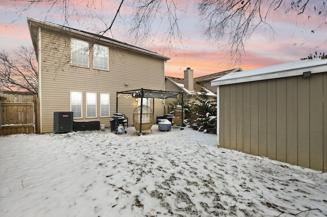 back of property at dusk with cooling unit and fence