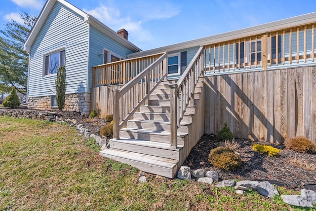 view of side of home featuring stairs and a chimney