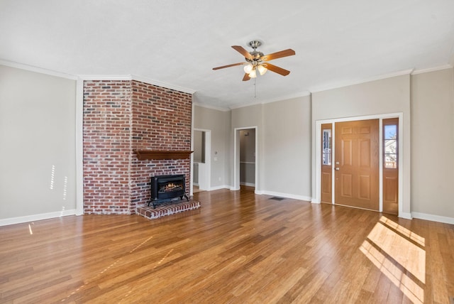 unfurnished living room featuring visible vents, crown molding, baseboards, and wood finished floors