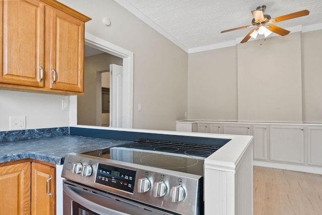 kitchen featuring dark countertops, light wood-style floors, ceiling fan, a textured ceiling, and stainless steel range with electric stovetop