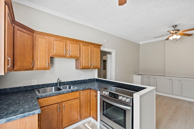 kitchen featuring dark countertops, stainless steel electric range oven, ceiling fan, a peninsula, and a sink