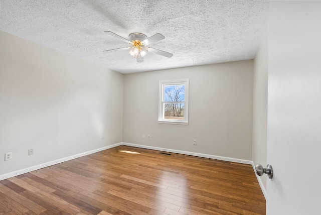 unfurnished room featuring baseboards, ceiling fan, a textured ceiling, and hardwood / wood-style floors