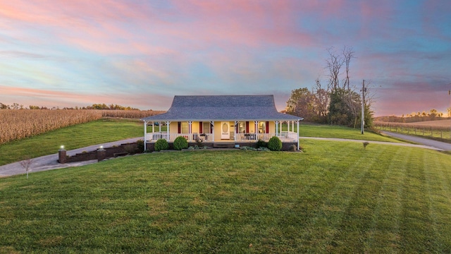 farmhouse-style home with a front yard, covered porch, and a rural view