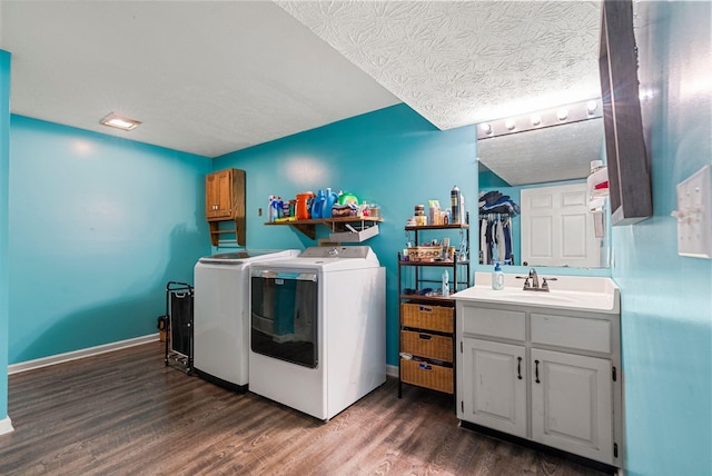 clothes washing area featuring baseboards, dark wood finished floors, washing machine and clothes dryer, a textured ceiling, and a sink