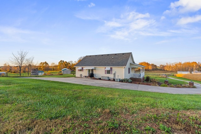 back of property featuring cooling unit and a lawn