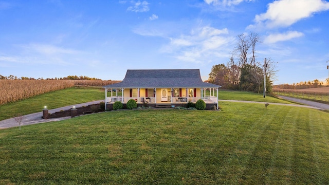 farmhouse with a front lawn, a porch, and a rural view