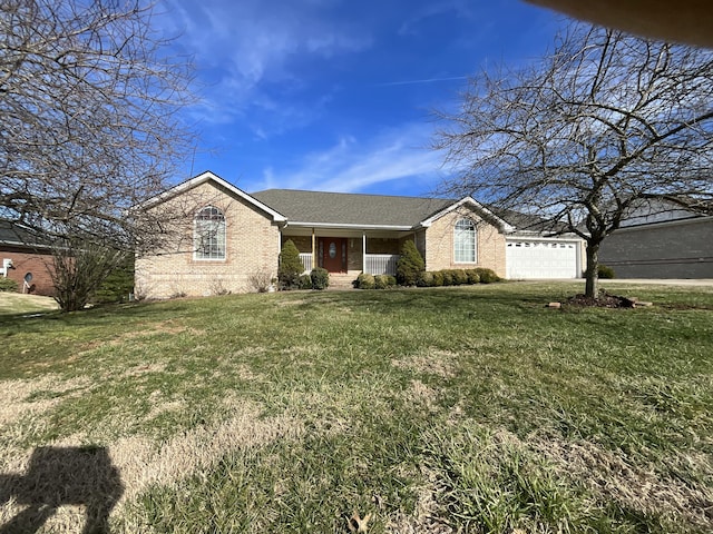 view of front of property with a garage, a front lawn, covered porch, and brick siding