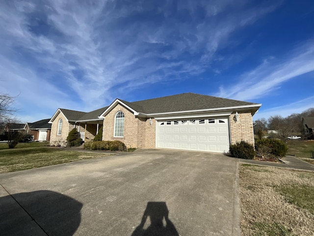 single story home featuring a garage, concrete driveway, brick siding, and a front lawn