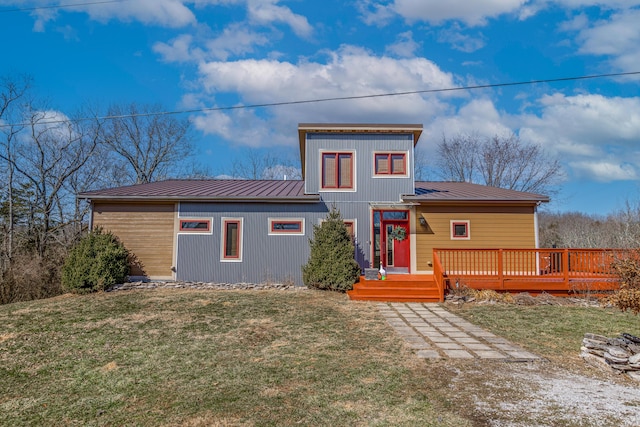 view of front of home featuring a deck, metal roof, a front lawn, and a standing seam roof