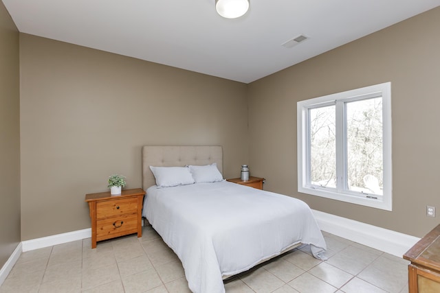 bedroom with light tile patterned floors, visible vents, and baseboards