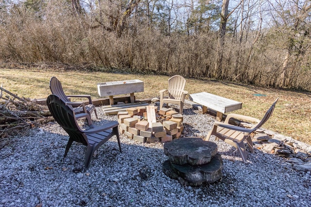 view of patio / terrace with a fire pit and a forest view