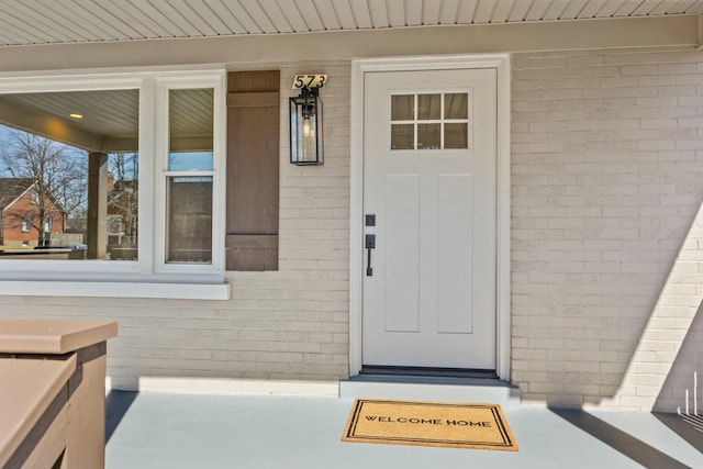 doorway to property featuring brick siding