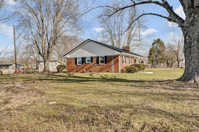 view of home's exterior featuring crawl space, brick siding, a lawn, and a chimney