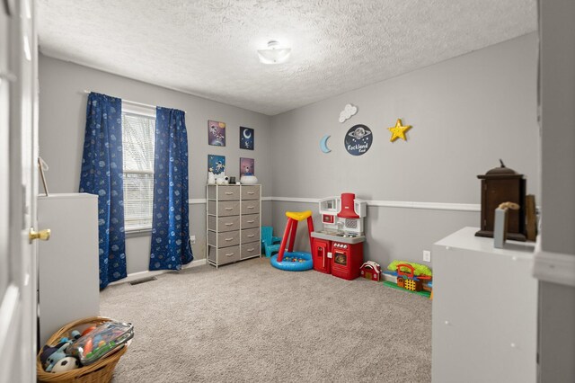 playroom featuring visible vents, carpet, and a textured ceiling