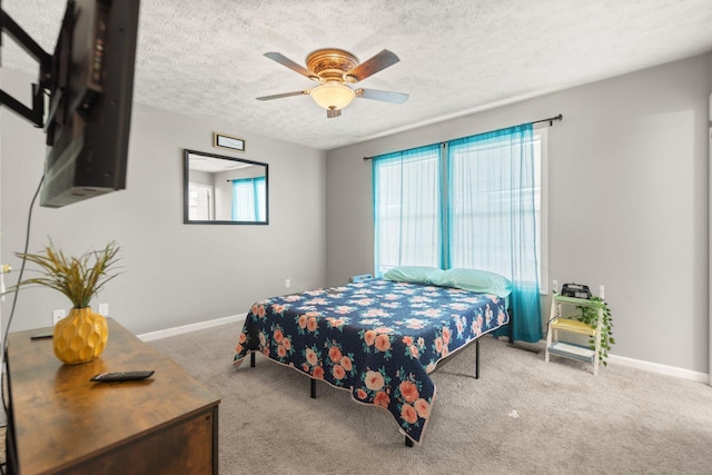 bedroom with a ceiling fan, baseboards, carpet floors, and a textured ceiling