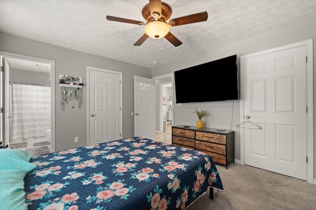 bedroom featuring light colored carpet, a textured ceiling, connected bathroom, and a ceiling fan