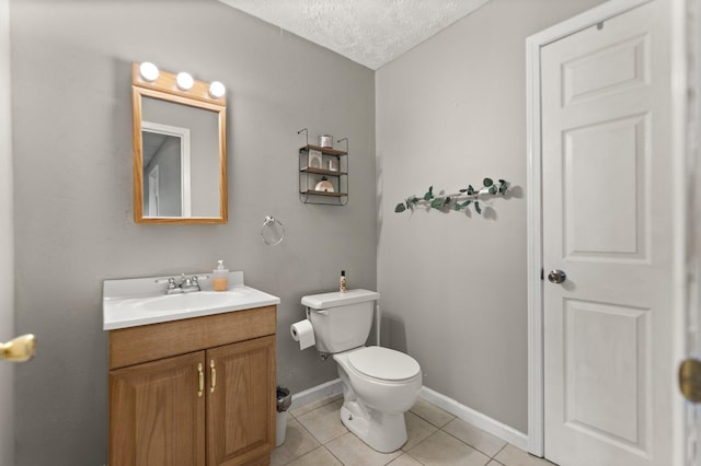 bathroom featuring tile patterned flooring, baseboards, toilet, vanity, and a textured ceiling