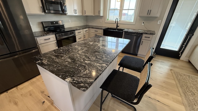 kitchen featuring electric range oven, freestanding refrigerator, a center island, dishwasher, and stainless steel microwave