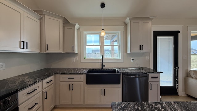 kitchen featuring pendant lighting, white cabinets, a sink, dark stone countertops, and dishwasher